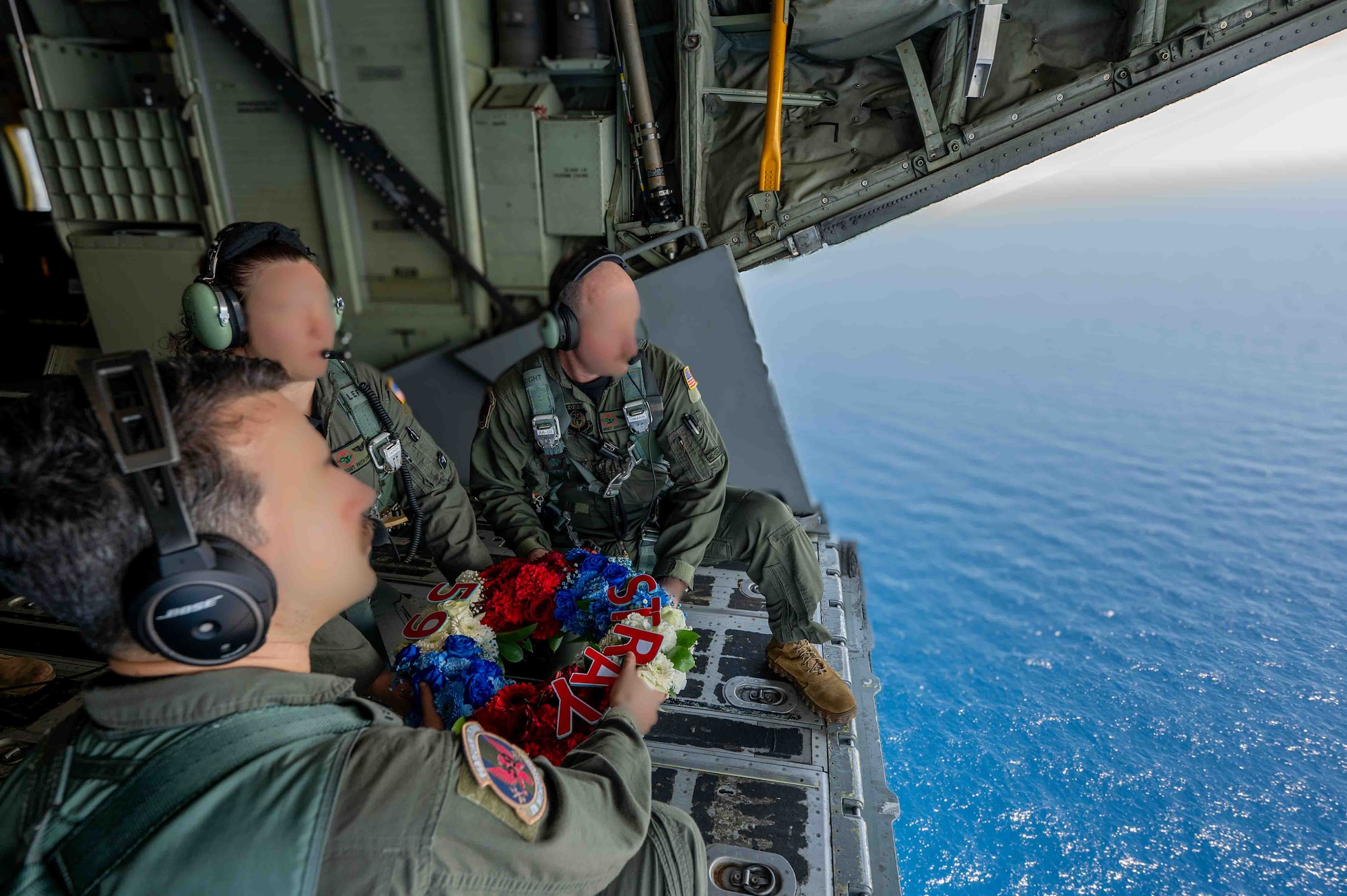 Service members release a wreath over the Philippine sea.