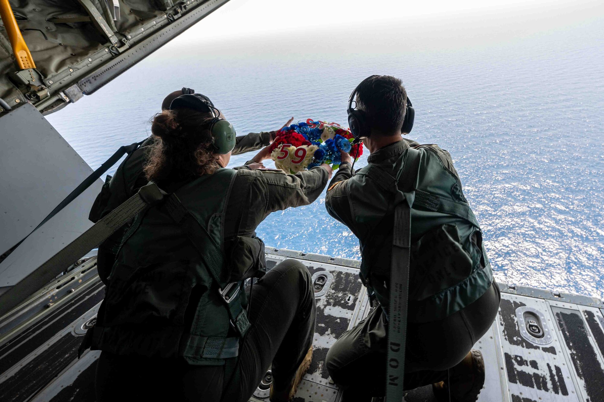 Service members release a wreath over the Philippine sea.