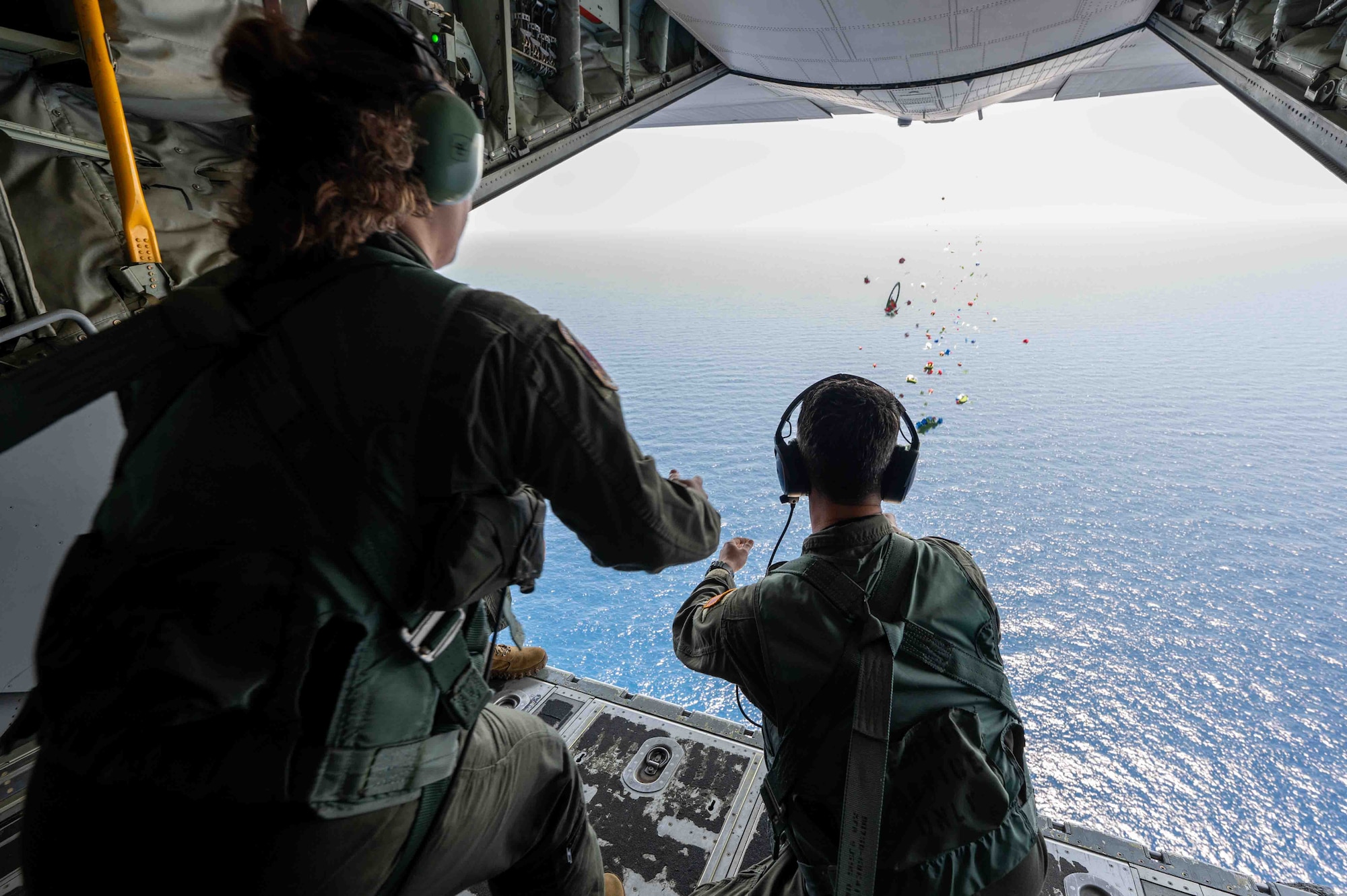 Service members release a wreath over the coast of the Philippines.