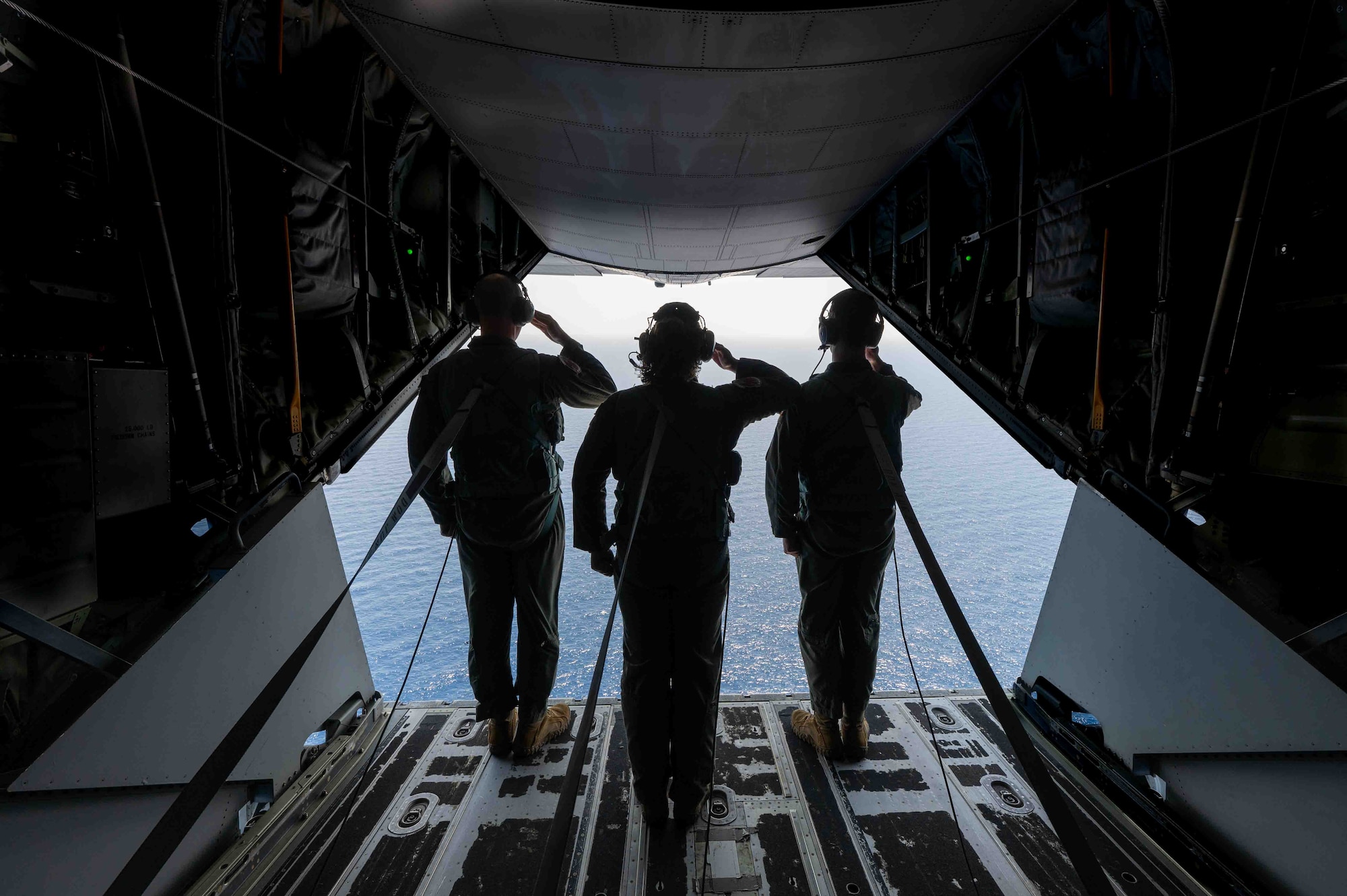 3 Service members salute at the crash site.