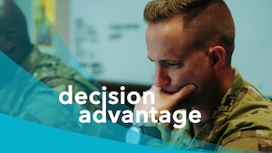 A military member sitting at a desk with his hand on his mouth giving the appearance of thinking.