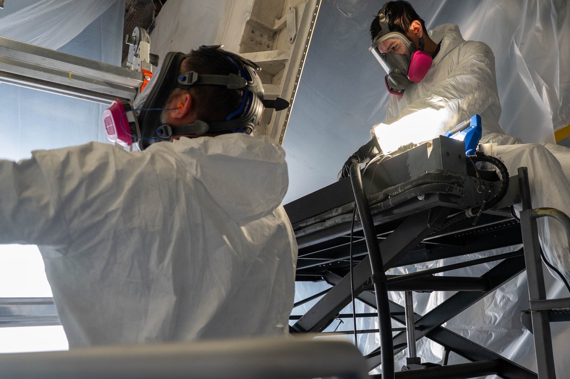 Marc Gilbert, Engineering and Software System Solutions, Inc. mechanical technician, left, and Ryan Kayton, ES3 mechanical technician, right, move equipment to begin a cold spray repair at Dyess Air Force Base, Texas, Feb. 20, 2026. The repair marked the first time the technique was performed at Dyess while the component remained installed on a B-1B Lancer. (U.S. Air Force photo by Airman 1st Class William Neal)