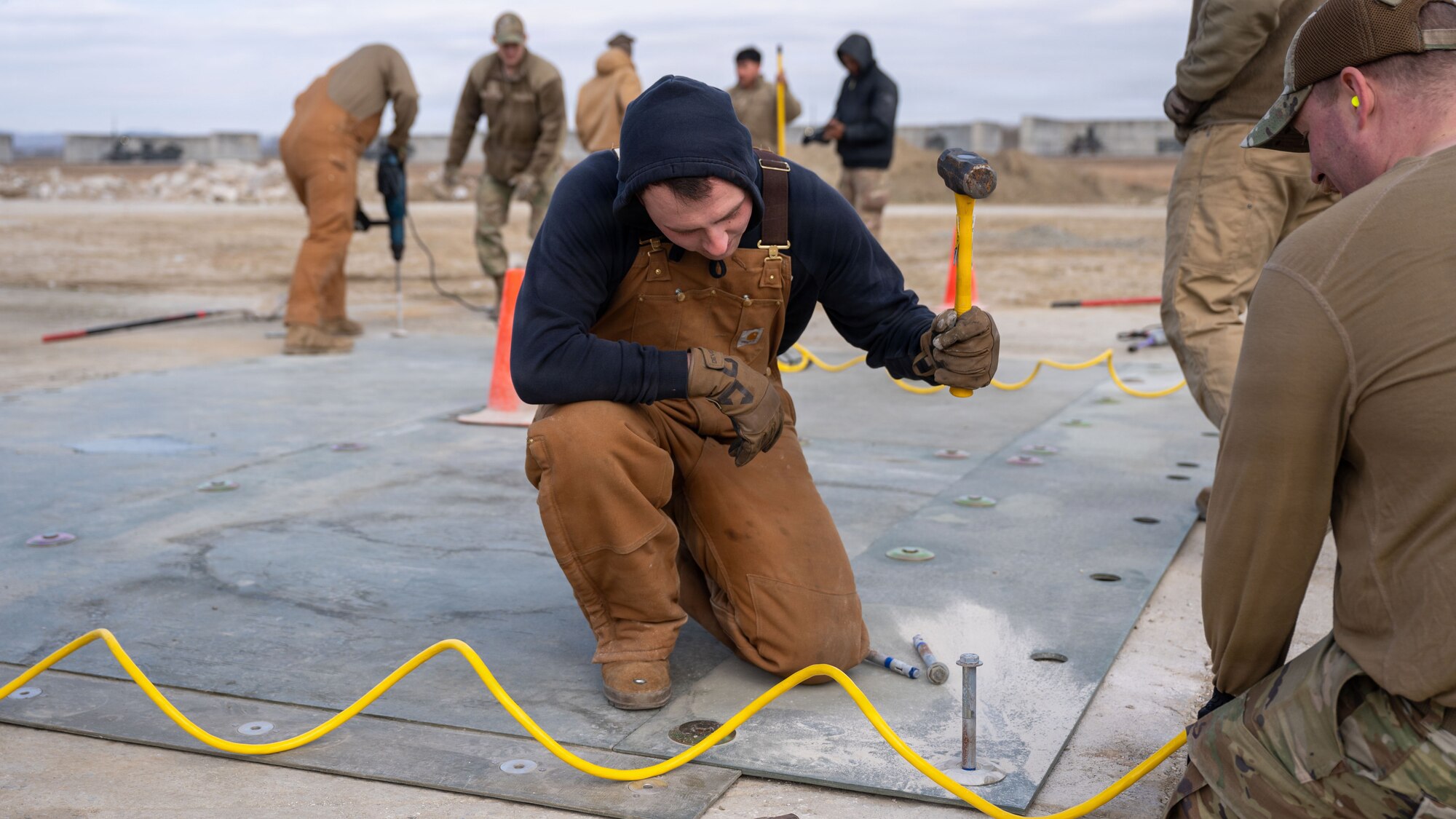 U.S. Air Force Senior Airman Elyjah James, 51st Civil Engineer Squadron structural journeyman, hammers down a screw during Rapid Osan Airfield Recovery training at Osan Air Base, Republic of Korea, Feb. 27, 2026. The Osan-developed recovery method prioritizes speed to achieve approximately 300 aircraft passes before transitioning to longer-term repair solutions. (U.S. Air Force photo by Senior Airman Rome Bowermaster)