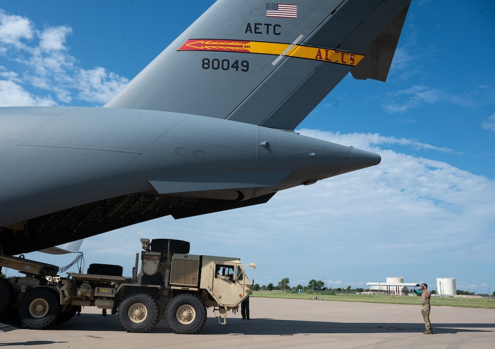 Staff Sgt. Dakota Maynor, 58th Airlift Squadron loadmaster, marshals a U.S. Army vehicle onto a C-17 Globemaster III aircraft during a training event at Altus Air Force Base, Okla., Aug. 20, 2025. The Airmen of Altus have been training with Soldiers from Fort Sill since at least 1999, offering decades of rapport, cohesiveness and increasing operational effectiveness. (U.S. Air Force photo by Tech. Sgt. Hailey Haux)