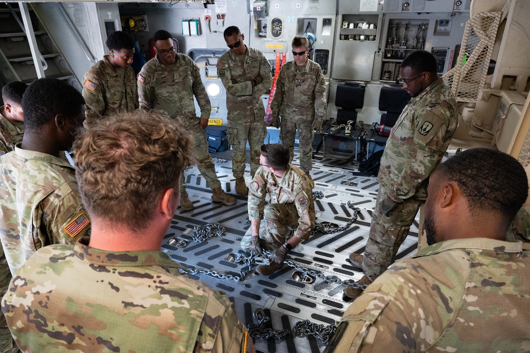Staff Sgt. Andrew Chatfield (center), 58th Airlift Squadron loadmaster, instructs U.S. Army Soldiers from Alpha Battery, 3-2 Air Defense Artillery, 31st ADA Brigade, 32 Air and Missile Defense Command on how to load their vehicles onto a C-17 Globemaster III aircraft for a training event at Altus Air Force Base, Okla., Aug. 20, 2025. Once each piece of equipment was uploaded and downloaded, the loadmasters talked through any difficulties they may come across in the future as well as how to overcome those challenges—giving them all the tools they would need to be successful in future operations. (U.S. Air Force photo by Tech. Sgt. Hailey Haux)