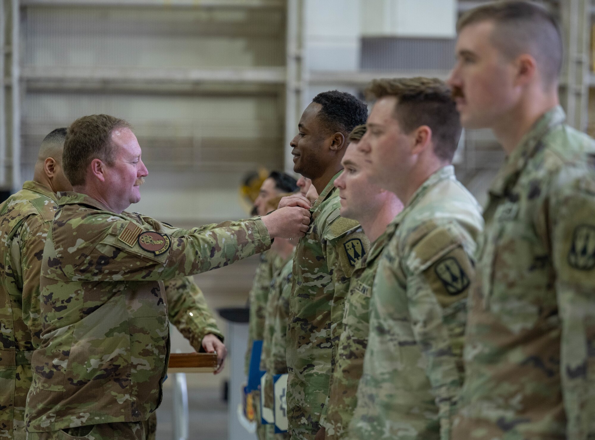 U.S. Air Force Lt. Col. Jonathan Taylor, 58th Airlift Squadron commander, pins the Air and Space Achievement Medal on a member of the 5-5 Air Defense Artillery Battalion, assigned to Fort Sill, at Altus Air Force Base, Oklahoma, March 4, 2026. Members of 5-5 Air Defense Artillery Battalion received the Air and Space Achievement Medal for their contributions to joint air mobility operations. (U.S. Air Force photo by Airman 1st Class Emma Wright)