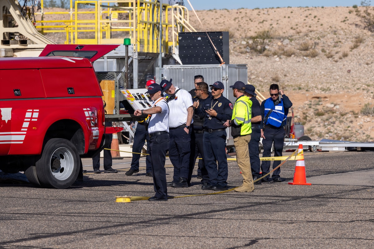 The Unified Incident Command, comprised of leadership from multiple local emergency and law enforcement agencies, gathers around the 162nd Wing's command vehicle to direct resource allocation during the incident response exercise at Tucson International Airport, Tucson, Arizona, February 25, 2026. Training exercises provide a valuable opportunity for leaders from multiple departments to practice agency integration, working together to provide an effective combined emergency response. (Photo by U.S. Air National Guard Tech. Sgt. Stephen Luke)