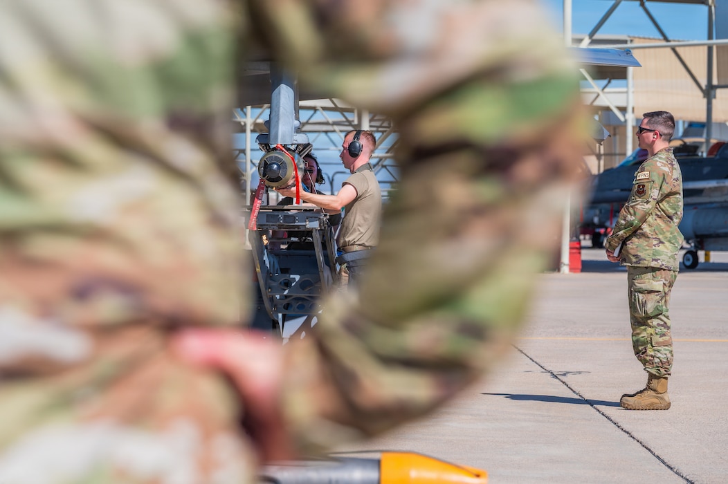 U.S. Air Force Staff Sgt. Derek Rushing (center), 62nd Aircraft Maintenance Unit weapons load crew chief and Staff Sgt. Dylan Kinney (right), 56th Maintenance Group squadron lead crew chief, participate in an annual weapons load competition, Feb. 27, 2026, at Luke Air Force Base, Arizona.