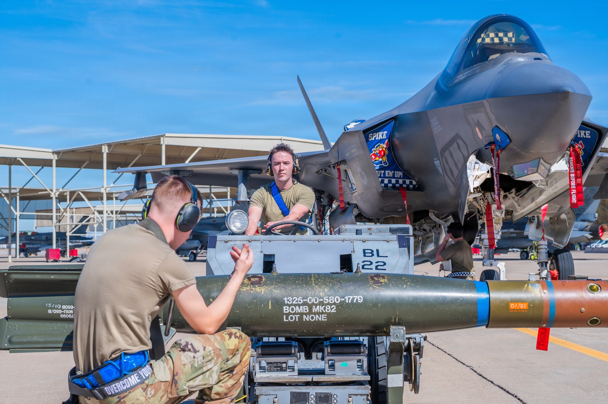 U.S. Air Force Senior Airman Keyden Petersen (center), 62nd Aircraft Maintenance Unit weapons load crew member, and Staff Sgt. Derek Rushing (left), 62nd Aircraft Maintenance Unit weapons load crew chief, participate in an annual weapons load competition, Feb. 27, 2026, at Luke Air Force Base, Arizona.