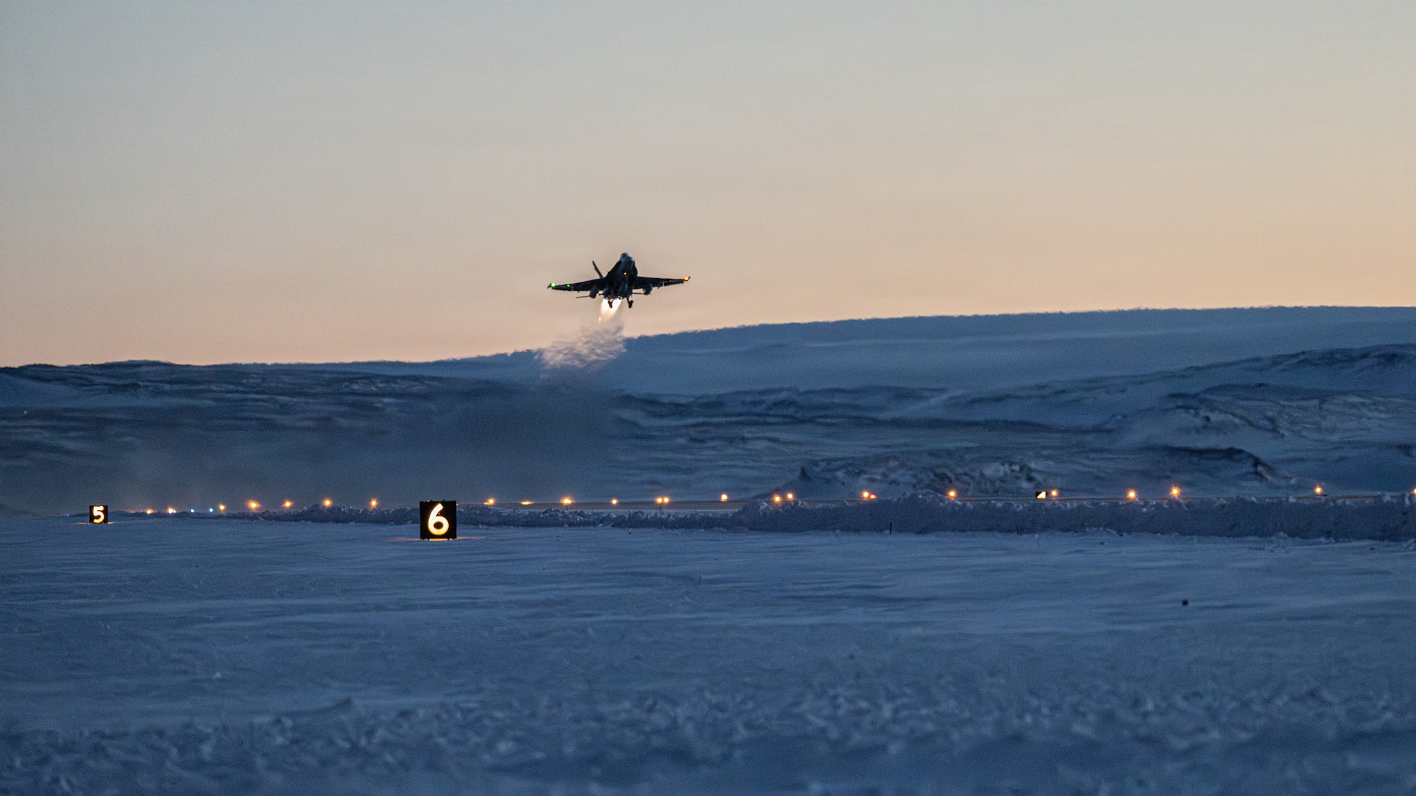 A Canadian CF-18 Hornet is departing the runway after takeoff.