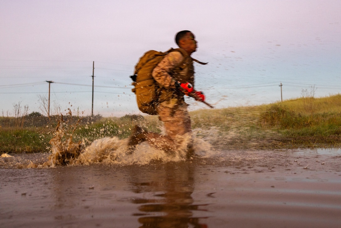 A U.S. Marine with Martial Arts Instructor Course 48-26 runs through water as part of the culminating event at Marine Corps Base Camp Pendleton, California, Feb. 26, 2026.