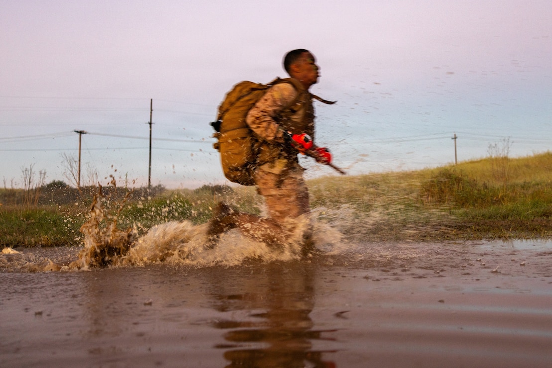 A U.S. Marine with Martial Arts Instructor Course 48-26 runs through water as part of the culminating event at Marine Corps Base Camp Pendleton, California, Feb. 26, 2026.