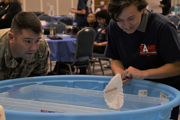 Lt. Col. Matthew Westcott, deputy commander of the U.S. Army Corps of Engineers Jacksonville District, observes high school students as they test their boat designs during the first “Surprise Problem” challenge at the 24th Annual Engineering Career Day Feb. 27, 2026, in Jacksonville, Florida. Using only provided materials, teams constructed small boats and added coins to test floatability and stability before the next phase of the challenge focused on mobility. (U.S. Army Corps of Engineers photo by Aaron Church)