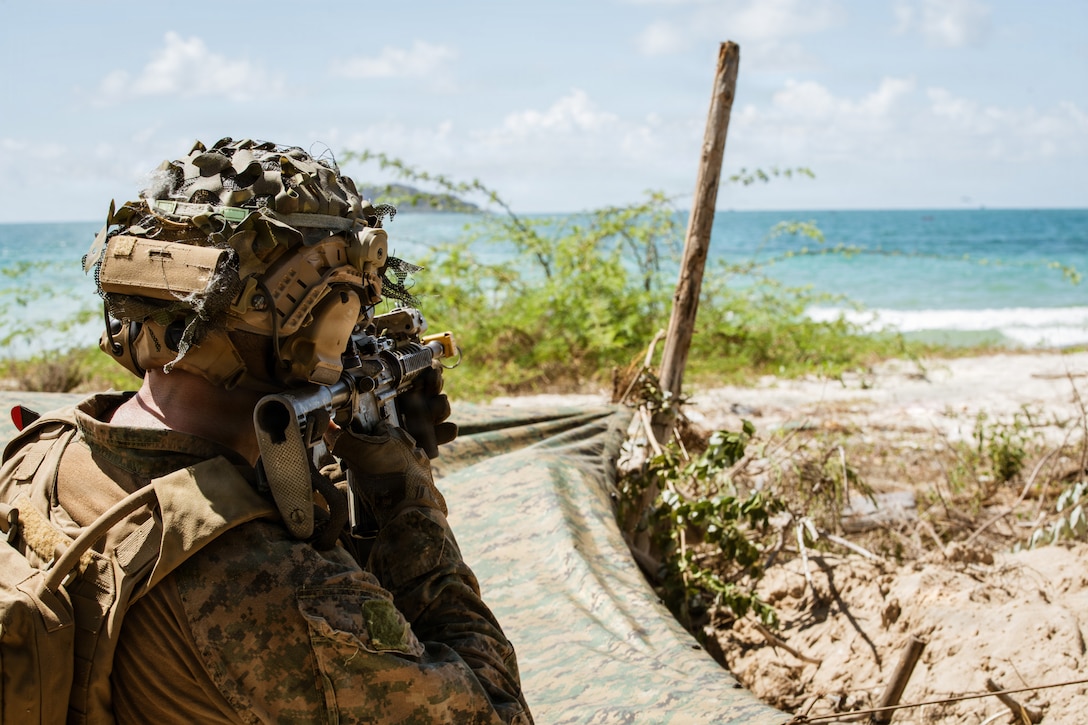 U.S. Marine Corps 2nd Lt. Isaac Gonzales, a platoon commander assigned to Task Force Ashland, I Marine Expeditionary Force, scans the coastline using his M4 carbine during a counter landing operation as part of Exercise Cobra Gold 2026 at Hat Yao beach, Rayong Province, Thailand, Feb. 28, 2026.