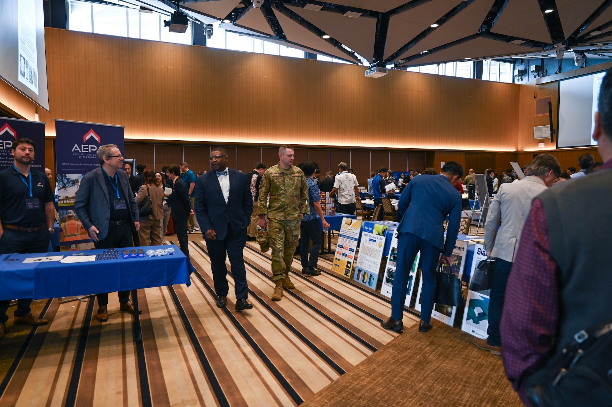 Civilians and service members look around event.