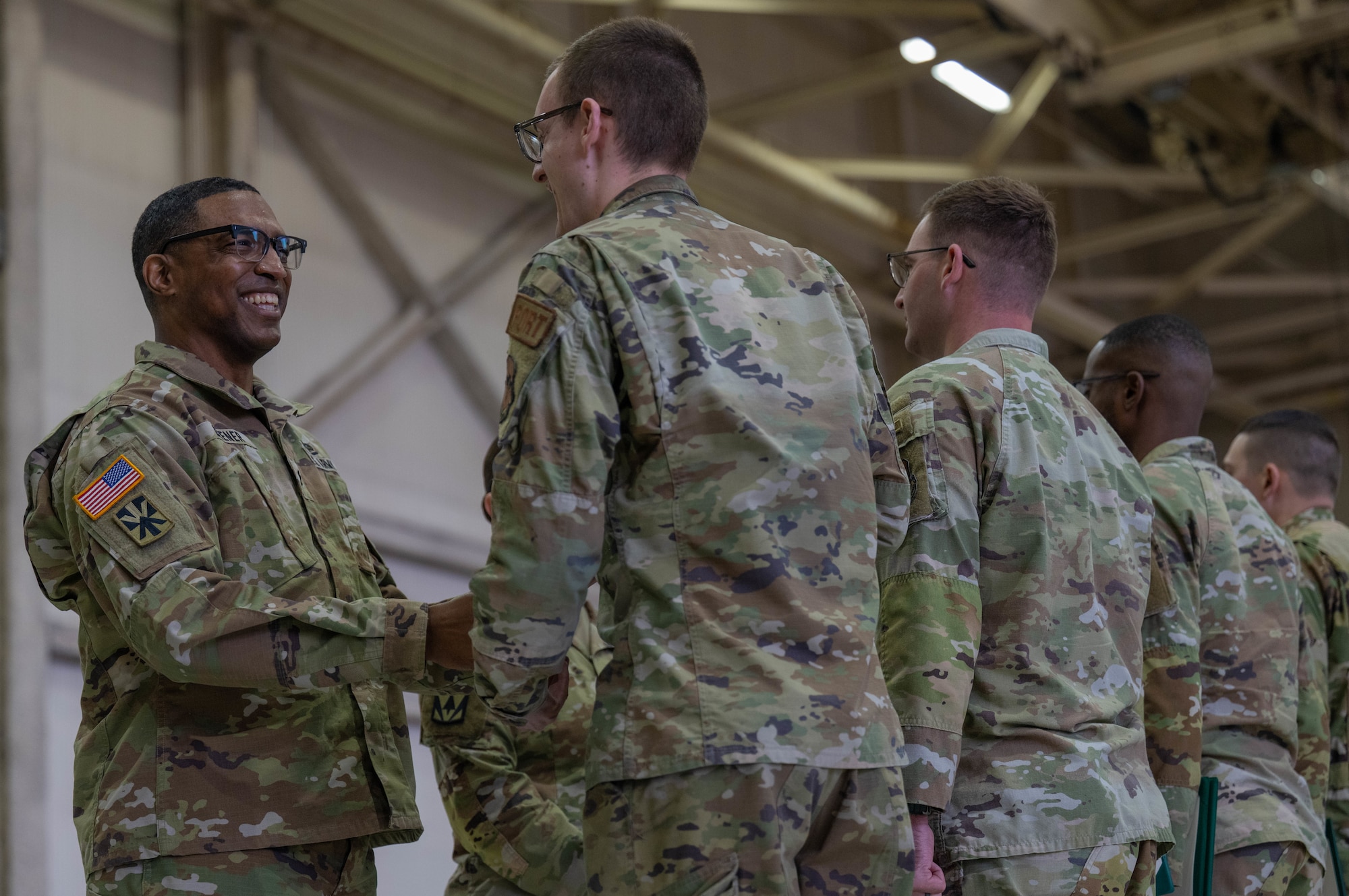 U.S. Army Lt Col. Dewayne Deener, commanding officer of the 5-5 Air Defense Artillery Battalion, shakes hands with a member of the 97th Logistics Readiness Squadron during a Joint Medals Ceremony at Altus Air Force Base, Oklahoma, March 4, 2026. While loading an Army combat vehicle onto a C-17 Globemaster III aircraft may appear straightforward, it requires meticulous coordination, technical expertise and strict adherence to safety standards. (U.S. Air Force photo by Airman 1st Class Emma Wright)