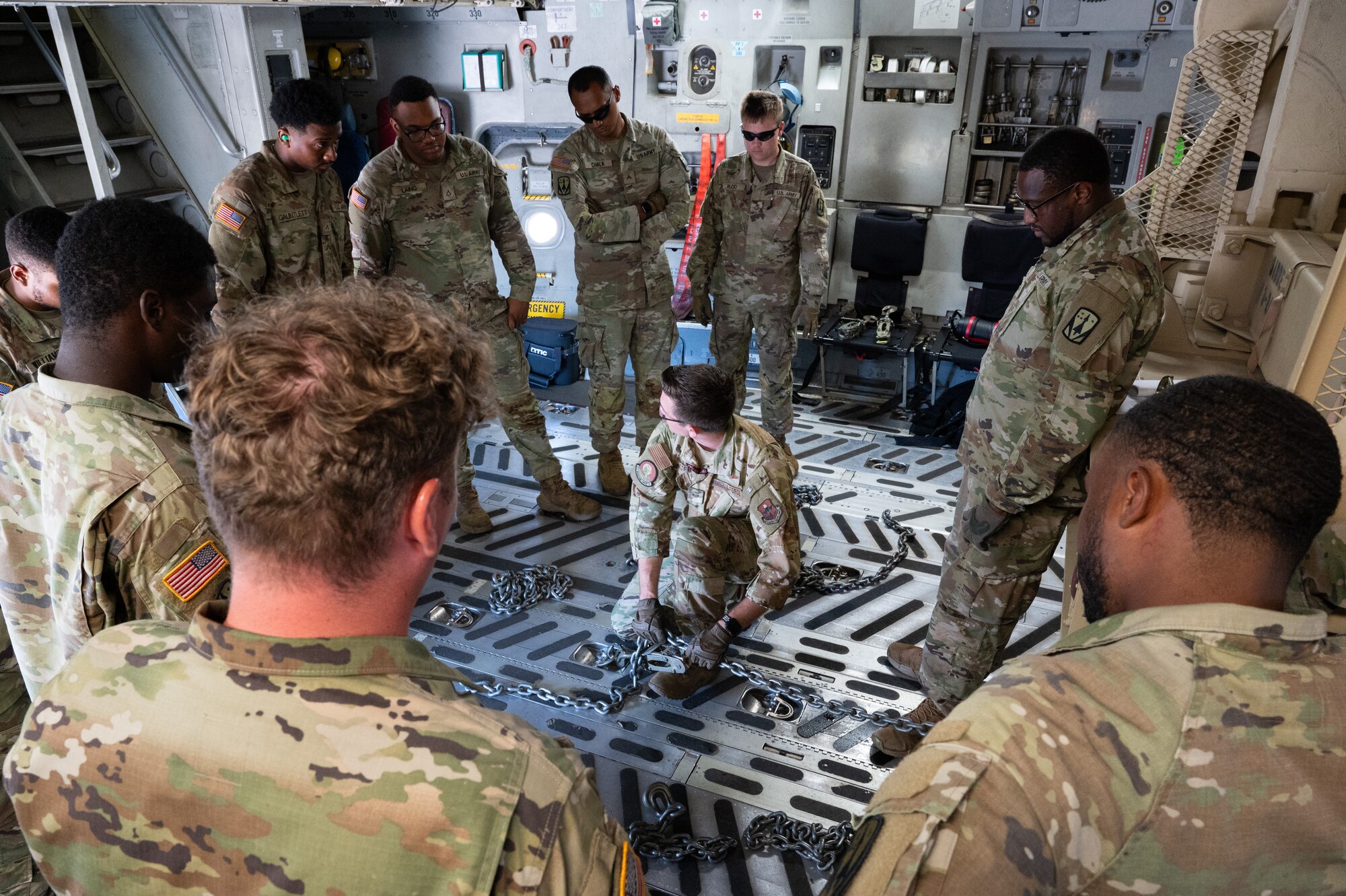 Staff Sgt. Andrew Chatfield (center), 58th Airlift Squadron loadmaster, instructs U.S. Army Soldiers from Alpha Battery, 3-2 Air Defense Artillery, 31st ADA Brigade, 32 Air and Missile Defense Command on how to load their vehicles onto a C-17 Globemaster III aircraft for a training event at Altus Air Force Base, Okla., Aug. 20, 2025. Once each piece of equipment was uploaded and downloaded, the loadmasters talked through any difficulties they may come across in the future as well as how to overcome those challenges—giving them all the tools they would need to be successful in future operations. (U.S. Air Force photo by Tech. Sgt. Hailey Haux)