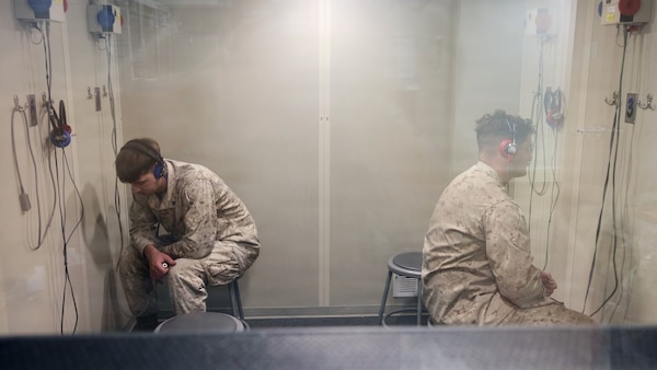 TWENTYNINE PALMS, Calif. (March 2, 2026) — Marine Corps Lance Cpl. Carson Groom, right, and Cpl. Volodymyr Shynkov receive audiometric hearing tests inside a soundproof audiometric booth at the Adult Medical Care Clinic aboard Marine Corps Air Ground Combat Center Twentynine Palms, March 2, 2026. The screening supports hearing conservation efforts that help ensure service members remain medically ready for operational missions. (U.S. Navy photo by Christopher Jones, NMRTC Twentynine Palms public affairs officer)
