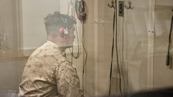 TWENTYNINE PALMS, Calif. (March 2, 2026) — Marine Corps Lance Cpl. Carson Groom undergoes an audiometric hearing test inside a soundproof audiometric booth at the Adult Medical Care Clinic aboard Marine Corps Air Ground Combat Center Twentynine Palms, March 2, 2026. The screening supports hearing conservation efforts that help ensure service members remain medically ready for operational missions. (U.S. Navy photo by Christopher Jones, NMRTC Twentynine Palms public affairs officer)