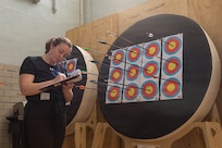 Elizabeth Spencer, a volunteer for the Army Recovery Program, records competitors' scores during an archery competition March 3, 2026.