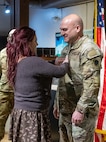 Sarah Crafton, the fiancé of newly promoted Maj. Aaron Bryant, tacks on new major rank during a promotion ceremony March 5 at the Illinois State Military Museum in Springfield.