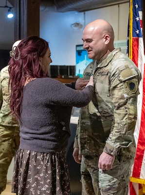 Sarah Crafton, the fiancé of newly promoted Maj. Aaron Bryant, tacks on new major rank during a promotion ceremony March 5 at the Illinois State Military Museum in Springfield.