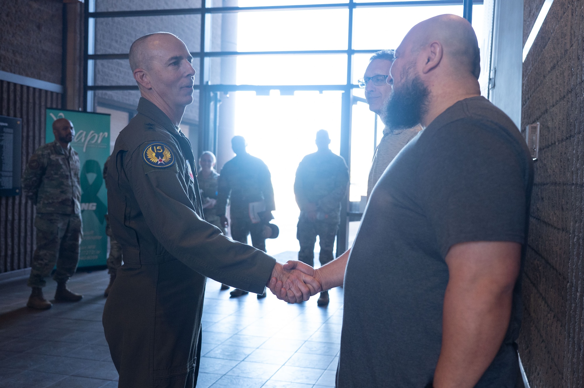 U.S. Air Force Maj. Gen. Steven Behmer, 15th Air Force commander, coins Juan Mejia, Sexual Assault Prevention and Response program liaison, at Davis-Monthan Air Force Base, Arizona, Feb. 27, 2026. The Sexual Assault Prevention and Response program works to prevent sexual assault and support the recovery of service members. (U.S. Air Force photo by Airman 1st Class Jaden Kidd)