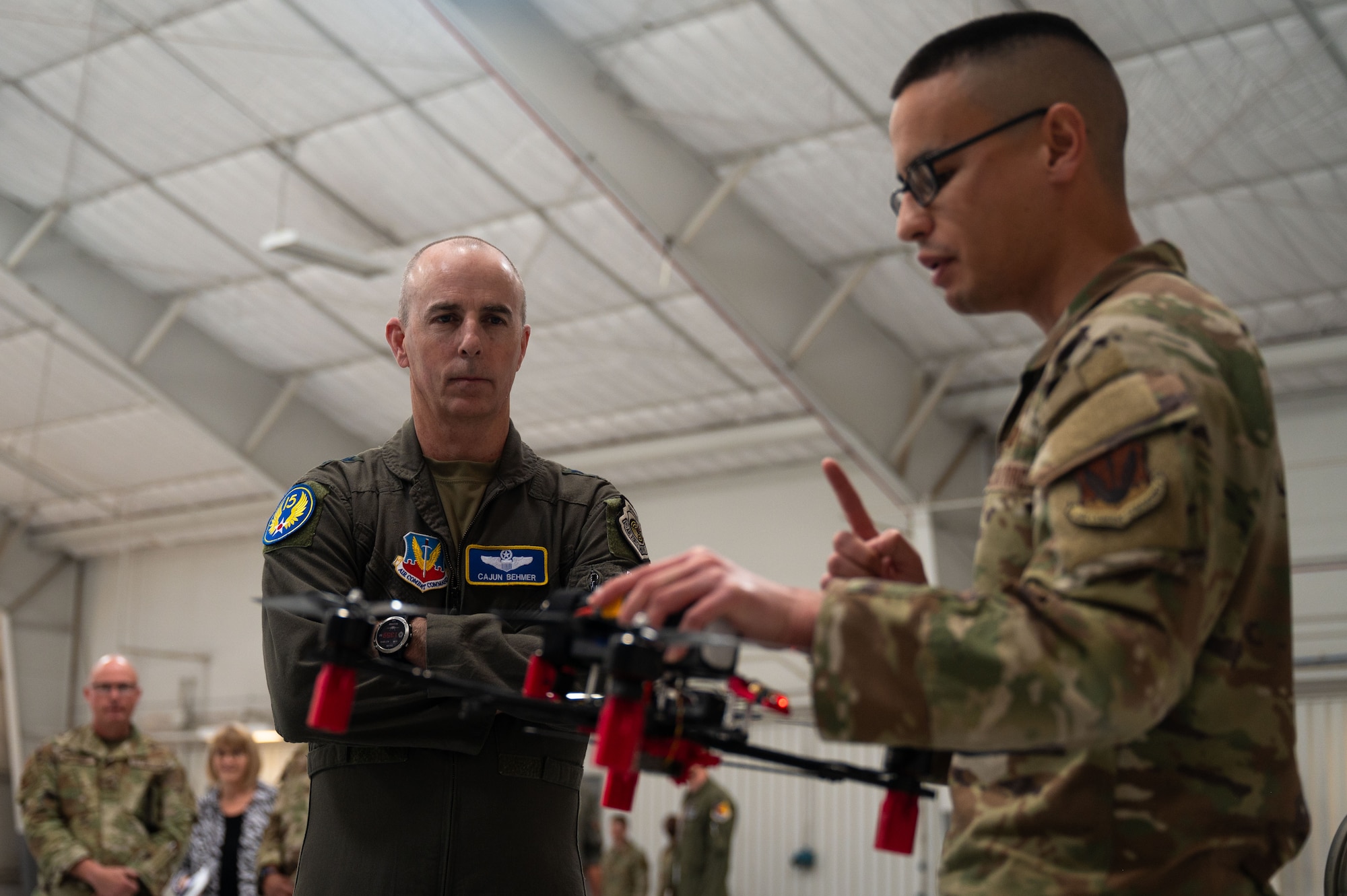 U.S. Air Force Maj. Gen. Steven Behmer, 15th Air Force commander, receives a briefing from Tech. Sgt. Joseph Peterson, 48th Rescue Squadron cyber transport technician, on the 355th Wing Drone Innovation Cell at Davis-Monthan Air Force Base, Arizona, Feb. 27, 2026. The cell develops and manufactures drones designed to support operational requirements at a reduced cost. (U.S. Air Force photo by Airman 1st Class Jaden Kidd)