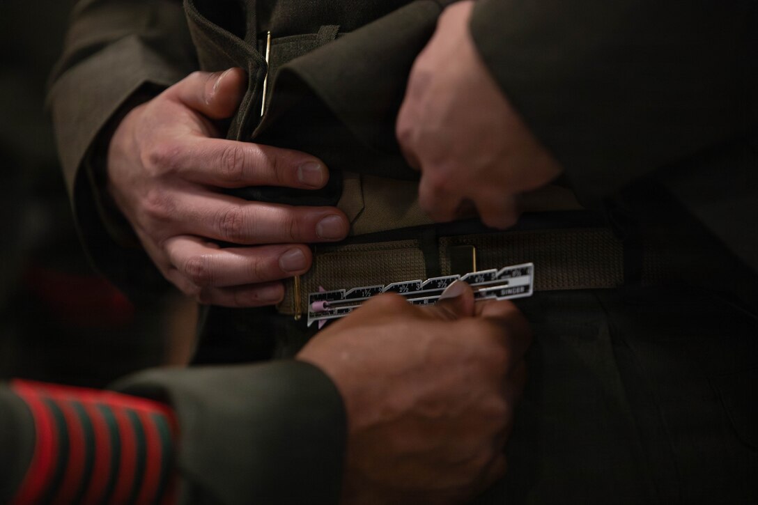 A U.S. Marine Corps web belt is inspected for length during a service alpha uniform inspection, Marine Corps Support Facility New Orleans, Feb. 27, 2026. The inspection was conducted to evaluate the Marines’ appearance and adherence to standards while promoting discipline and attention to detail. The Marine Corps uniform standard of grooming allows conservative and inconspicuous styles of nail polish. (U.S. Marine Corps photo by Lance Cpl. Van Hoang)