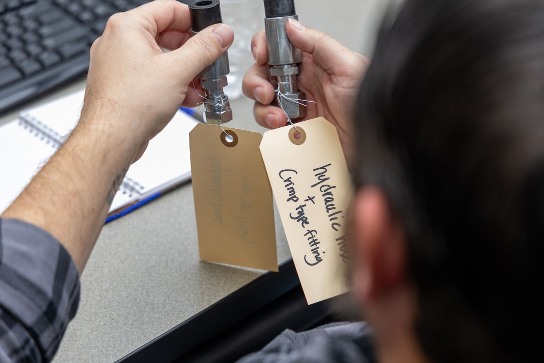 A person looks at two fittings in a classroom.