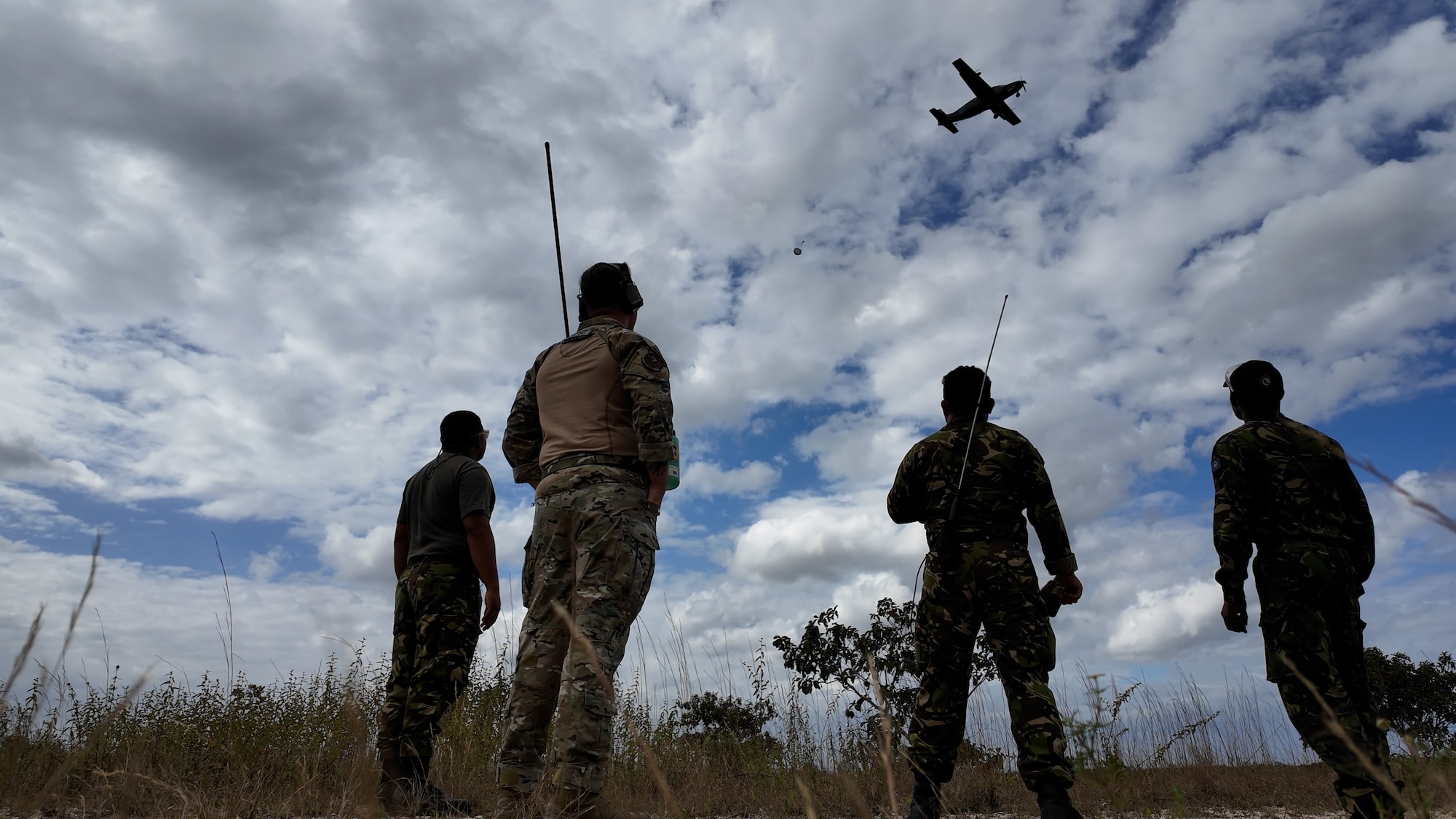 men watch plane from field