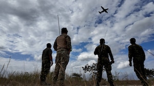 men watch plane from field