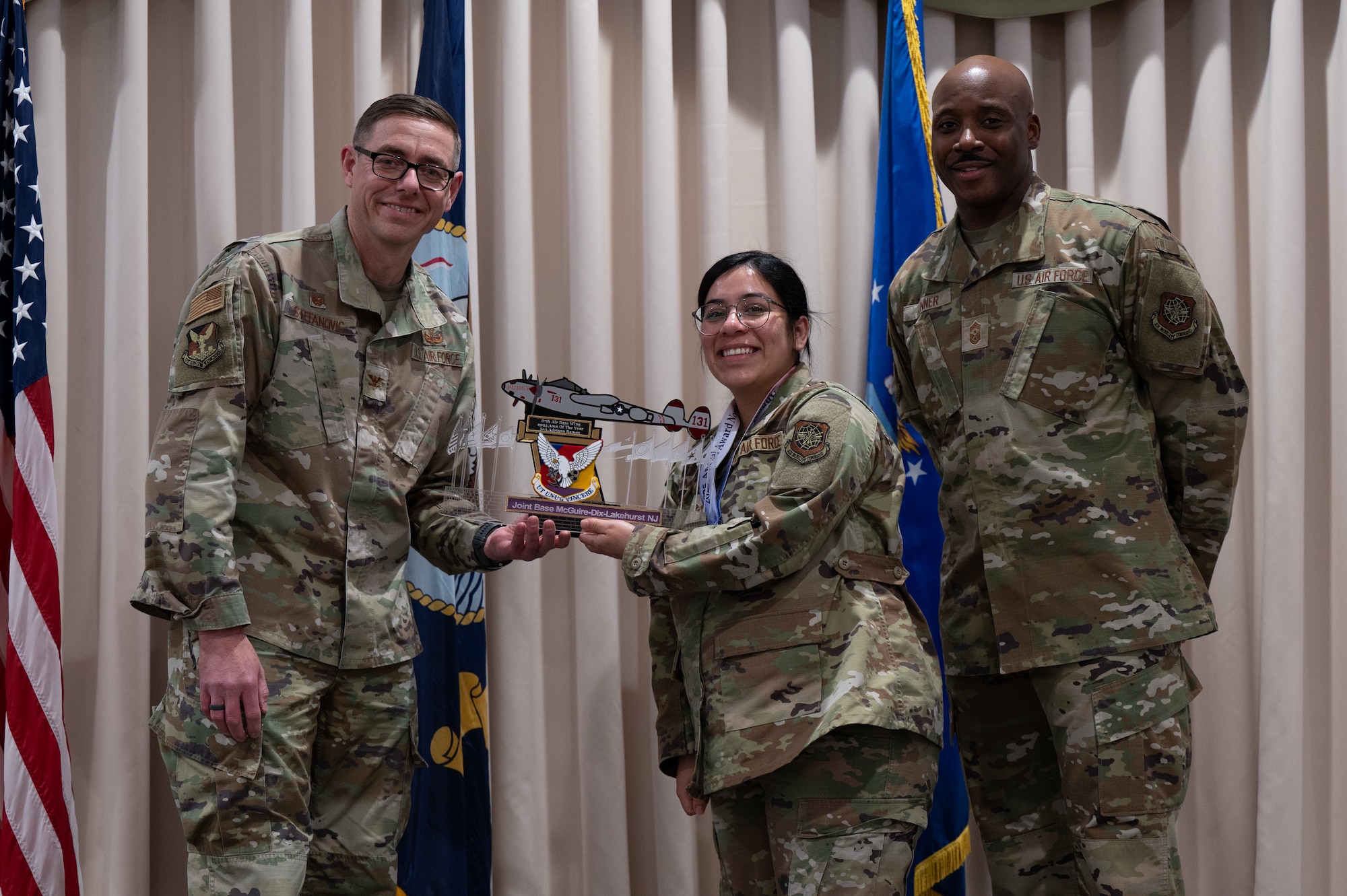 U.S. Air Force Senior Airman Adriana Ramos, center, 87th Medical Support Squadron medical information systems technician, accepts an award from Col. Michael Stefanovic, Joint Base McGuire-Dix-Lakehurst and 87th Air Base Wing commander, and Chief Master Sgt. Nicholas Conner, 87th ABW command chief, at JB MDL, N.J., Feb. 26, 2026.