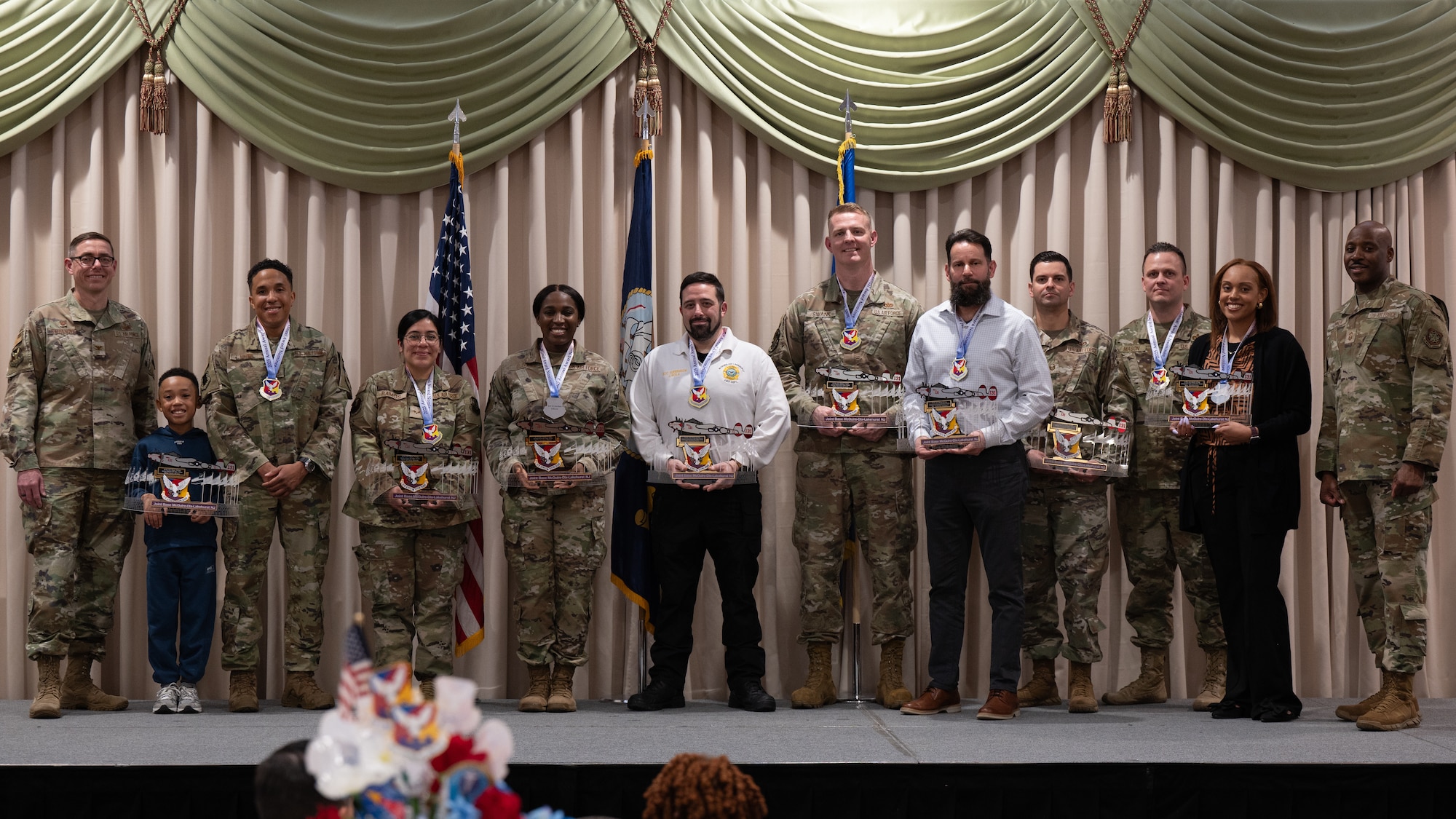 The 87th Air Base Wing 2025 annual award winners pose for a photo with the installation command team during the annual awards ceremony at Joint Base McGuire-Dix-Lakehurst, N.J., Feb. 26, 2026.