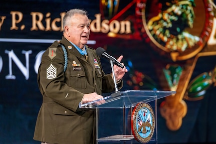 Retired U.S. Army Command Sgt. Maj. Terry P. Richardson speaks behind a podium during a Hall of Heroes Induction Ceremony at Conmy Hall.