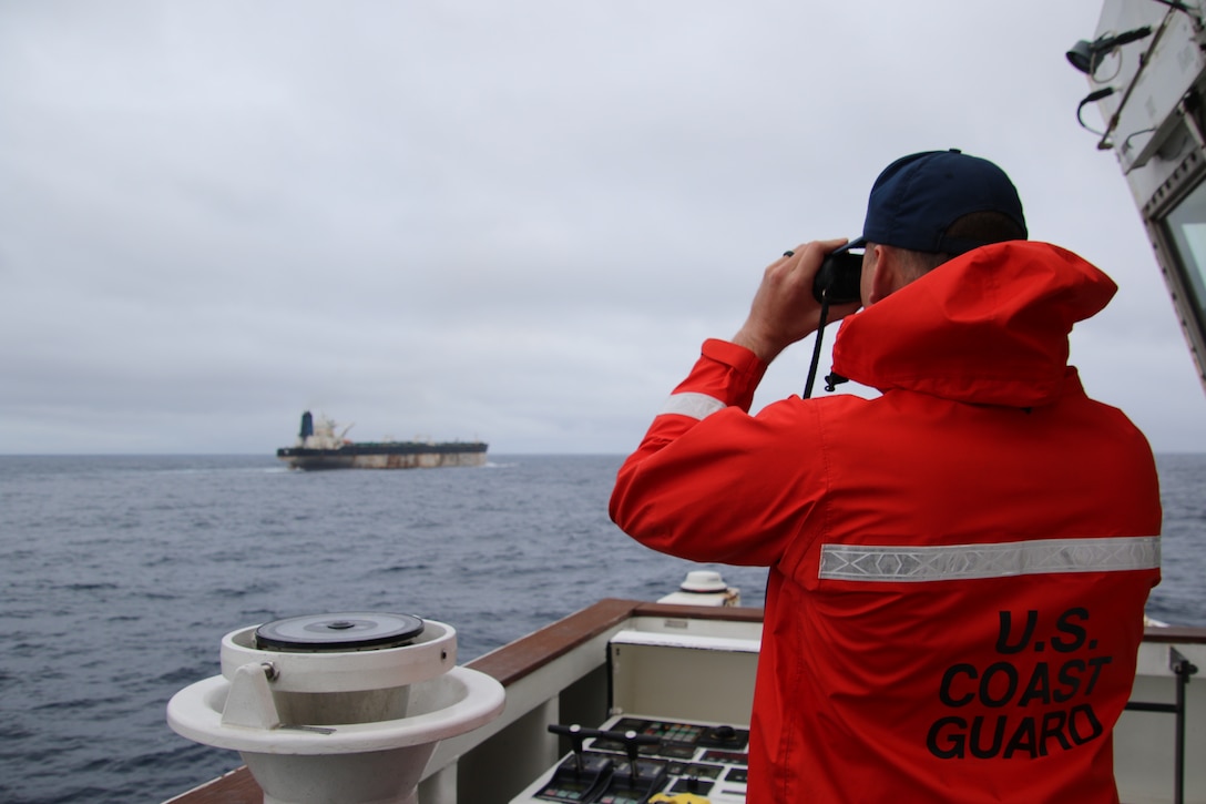 A Coast Guard Cutter Munro (WMSL 755) crew member observes the oil tanker Bella 1 in the North Atlantic Ocean, Jan. 6, 2026. Munro’s crew monitored the vessel until it was seized by Coast Guard deployable specialized forces, with support from the Department of War, after Bella 1 violated U.S. sanctions and resisted initial boarding attempts off coastal Venezuela in late December. (U.S. Coast Guard photo)