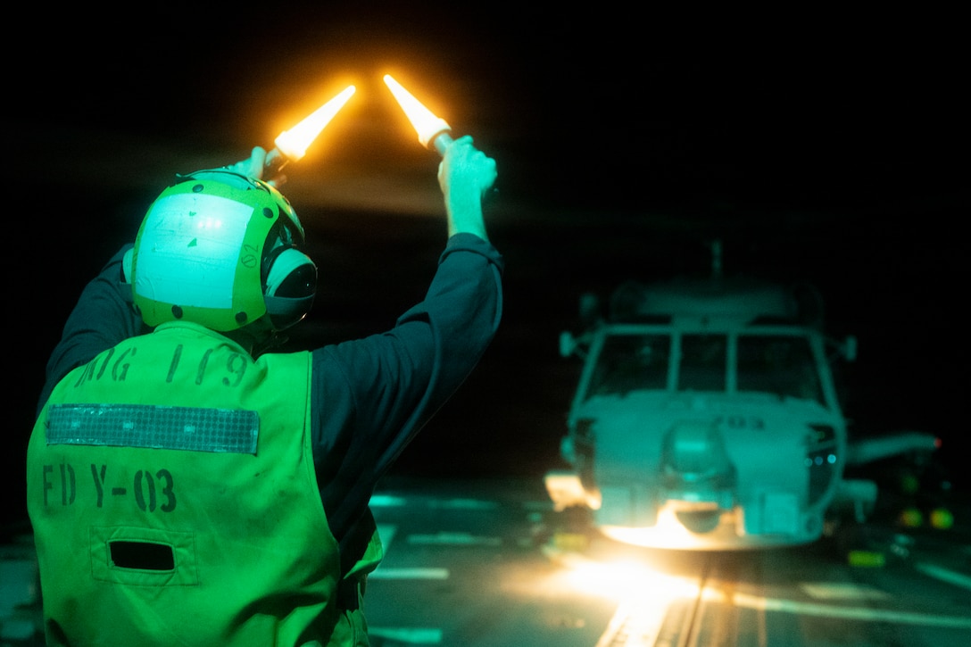 A U.S. Sailor assigned to Arleigh Burke-class guided-missile destroyer USS Delbert D. Black (DDG 119) directs an MH-60R Sea Hawk helicopter, attached to Helicopter Maritime Strike Squadron (HSM) 46, during a flight quarter evolution in the U.S. Central Command area of responsibility in support of Operation Epic Fury, Mar. 5, 2026. (U.S. Navy photo)