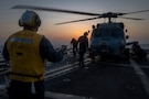 A U.S. Sailor assigned to Arleigh Burke-class guided-missile destroyer USS Delbert D. Black (DDG 119) directs an MH-60R Sea Hawk helicopter, attached to Helicopter Maritime Strike Squadron (HSM) 46, during a flight quarter evolution in the U.S. Central Command area of responsibility in support of Operation Epic Fury, Mar. 7, 2026. (U.S. Navy photo)