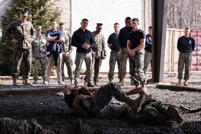 The Honorable Hung Cao, Under Secretary of the Navy, center, and U.S. Marines with The Basic School, observe a Marine Corps Martial Arts Program demonstration at Marine Corps Base Quantico, Virginia, Feb. 27, 2026. During a visit to TBS and Officer Candidates School, Cao met with senior leaders and Marines to observe training and gain a deeper understanding of the methods the Marine Corps uses to train, screen, and evaluate its candidates and newly commissioned officers.