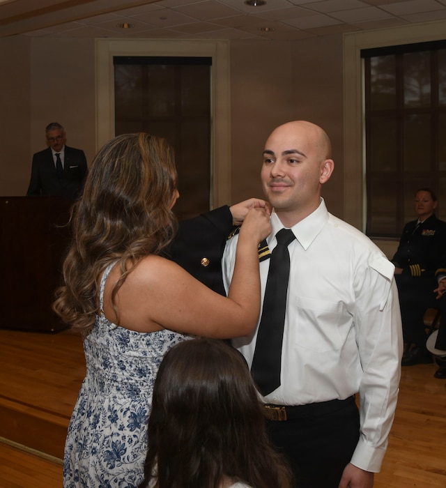 260306-N-FB730-1069 CAMP LEJEUNE. (March 6, 2026)Lt. j.g. Nelyavier Meletiche has his officer shoulder boards placed by his family during the Interservice Physicians Assistants Program (IPAP) graduation at Marston Pavilion on March 6, 2026.  Naval Medical Center Camp Lejeune serves as a Phase II site for Navy Medicine’s Interservice Physician Assistant Program. The program has graduated and commissioned more than 35 Navy officers since the program’s establishment in 2021. (U.S. Navy photo by Mass Communications Specialist second class Justin Woods)