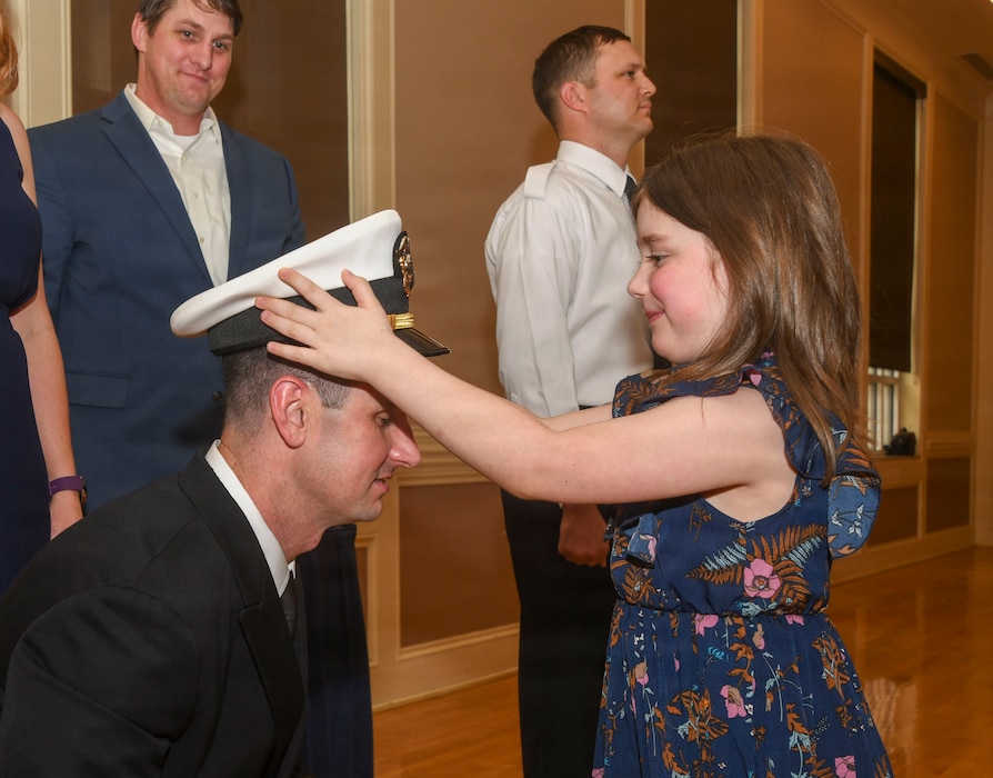 260306-N-FB730-1078 CAMP LEJEUNE. (March 6, 2026) Lt. j.g.  Brandon Smith has his officer cover placed by his daughter during the Interservice Physicians Assistants Program (IPAP) graduation at Marston Pavilion on March 6, 2026.  Naval Medical Center Camp Lejeune serves as a Phase II site for Navy Medicine’s Interservice Physician Assistant Program. The program has graduated and commissioned more than 35 Navy officers since the program’s establishment in 2021. (U.S. Navy photo by Mass Communications Specialist second class Justin Woods)