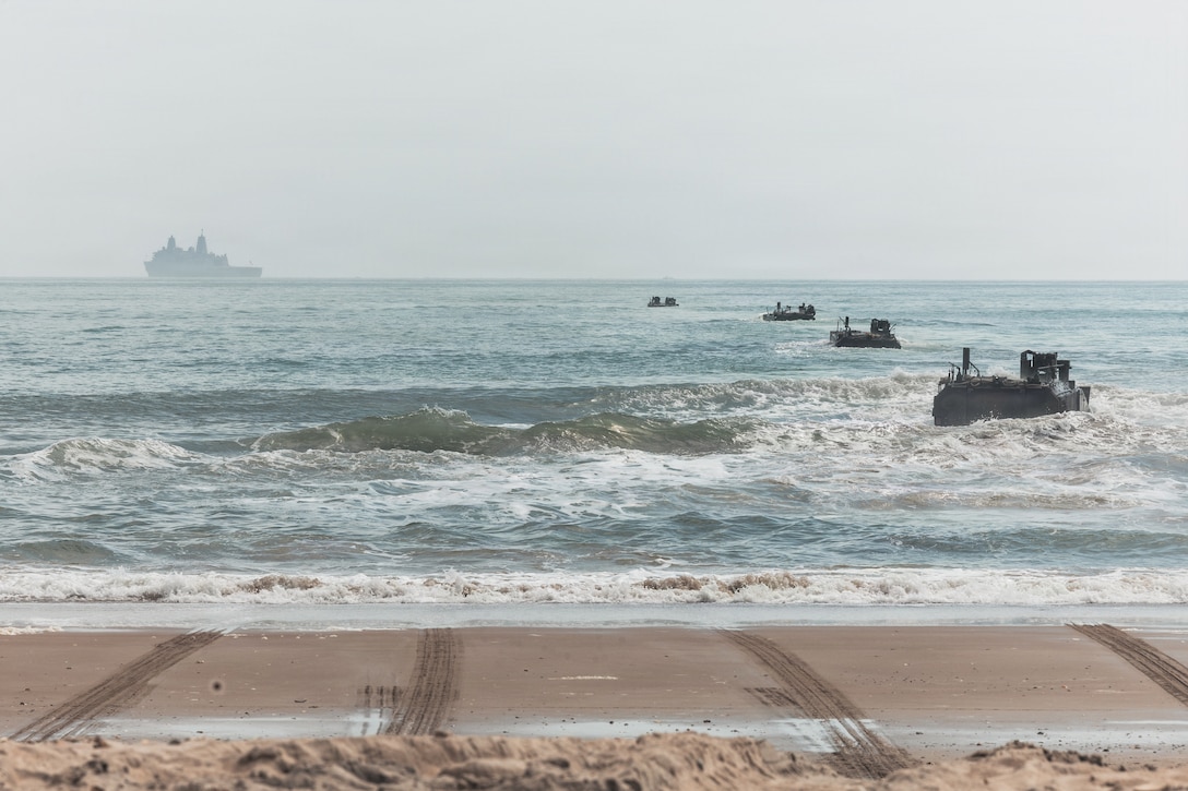 U.S. Marine Corps Amphibious Combat Vehicles with Alpha Company, 2nd Assault Amphibian Battalion, 2nd Marine Division, traverse offshore towards the San Antonio-class amphibious transport dock ship USS Arlington (LPD 24), at Onslow Beach during Type Commander’s Amphibious Training 26.1 at Marine Corps Base Camp Lejeune, N.C., March 3, 2026. TCAT is a military exercise designed to enhance mobility and integration between the U.S. Marine Corps and the U.S. Navy. It allows Marines and Sailors to gain hands-on experience of working side by side in amphibious planning and operations, including the use of multiple surface connectors and air platforms. The training focuses on improving the necessary skills for real-world operations and effective collaboration between Marine Corps and Naval teams. (U.S. Marine Corps photo by Sgt. Jorge Borjas)