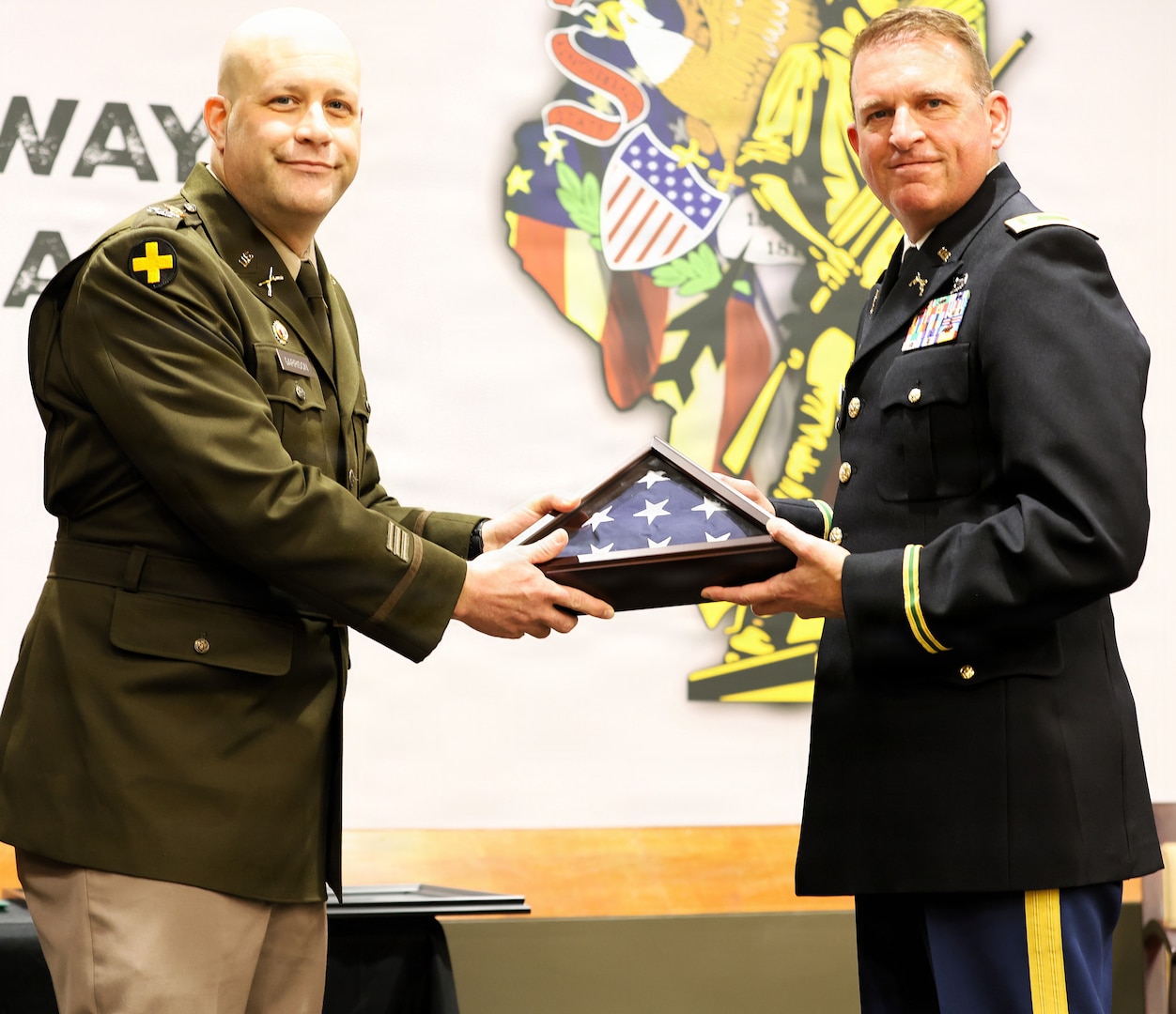 Col. Matthew Garrison, the Illinois National Guard Chief of the Joint Staff and Director of Strategic Plans and Policies for the Illinois National Guard, presents a retirement flag to Lt. Col. Justin Wilkerson, Joint Deputy Operations Officer for the Illinois Army National Guard, during Wilkerson’s retirement ceremony.
