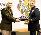 Col. Matthew Garrison, the Illinois National Guard Chief of the Joint Staff and Director of Strategic Plans and Policies for the Illinois National Guard, presents a retirement flag to Lt. Col. Justin Wilkerson, Joint Deputy Operations Officer for the Illinois Army National Guard, during Wilkerson’s retirement ceremony.