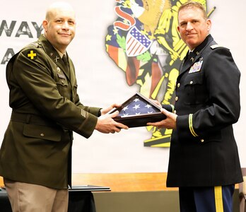 Col. Matthew Garrison, the Illinois National Guard Chief of the Joint Staff and Director of Strategic Plans and Policies for the Illinois National Guard, presents a retirement flag to Lt. Col. Justin Wilkerson, Joint Deputy Operations Officer for the Illinois Army National Guard, during Wilkerson’s retirement ceremony.