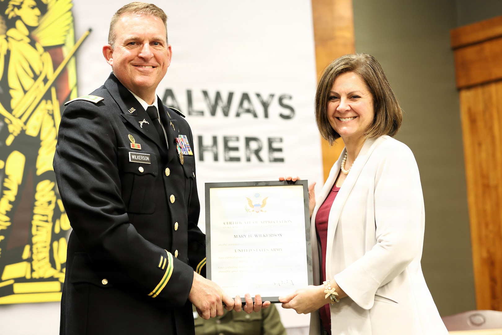 Lt. Col. Justin Wilkerson presents a certificate of appreciation to his wife, Mary Wilkerson, during his retirement ceremony.