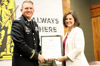 Lt. Col. Justin Wilkerson presents a certificate of appreciation to his wife, Mary Wilkerson, during his retirement ceremony.