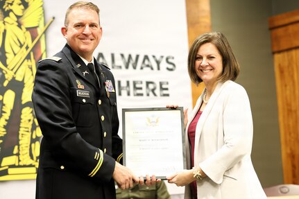 Lt. Col. Justin Wilkerson presents a certificate of appreciation to his wife, Mary Wilkerson, during his retirement ceremony.