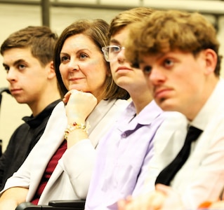 Mary Wilkerson listens to her spouse, Lt. Col. Justin Wilkerson, speak during his retirement ceremony.
