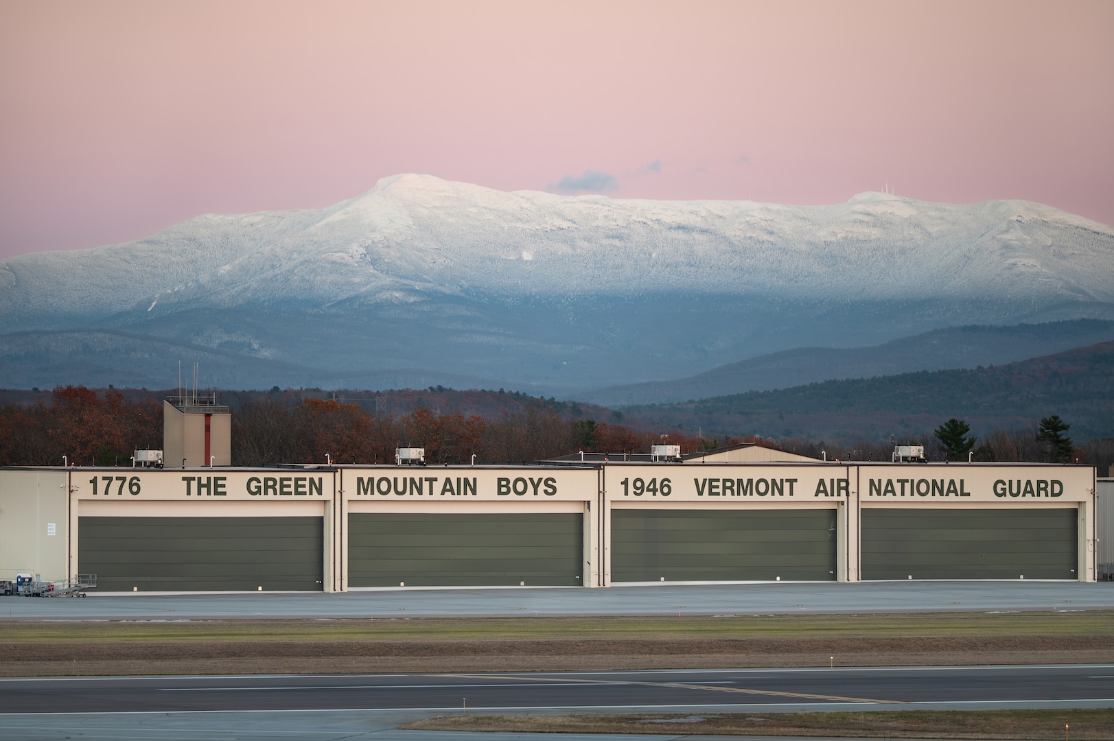 A Vermont Air National Guard hangar, assigned to the 158th Fighter Wing, sits below Mount Mansfield after sunset in South Burlington, Vermont, Nov. 19, 2025. The 158th Fighter Wing conducted flying operations that evening. (U.S. Air National Guard photo by Airman 1st Class Raymond LaChance)